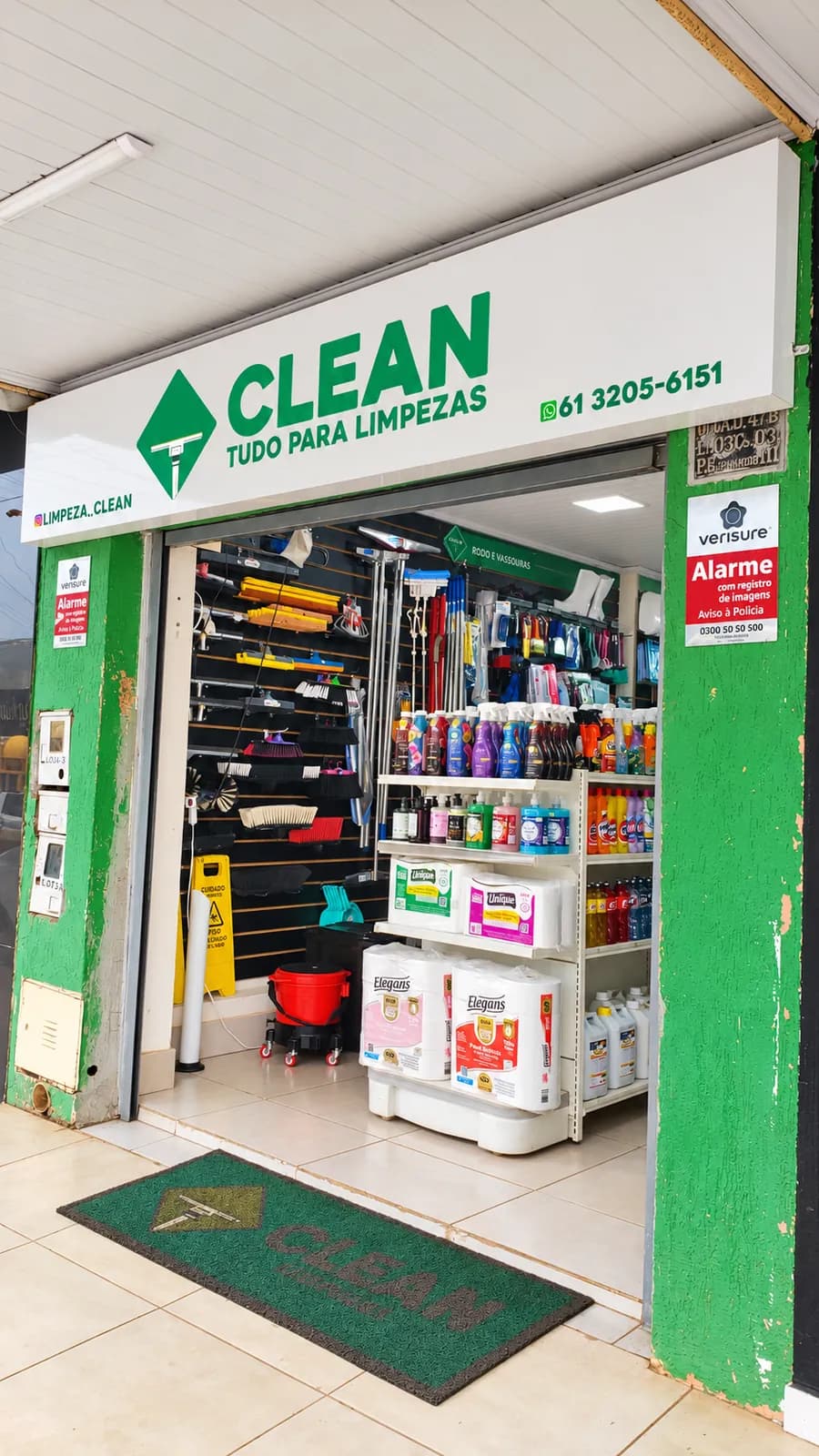 Entrada da loja Clean Limpezas com a placa Tudo para limpezas, rodos, vassouras e prateleiras de papel e produtos